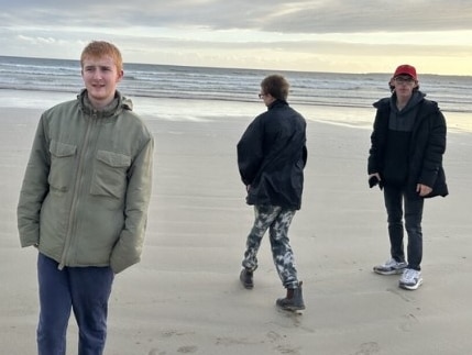 Three young people on the beach.